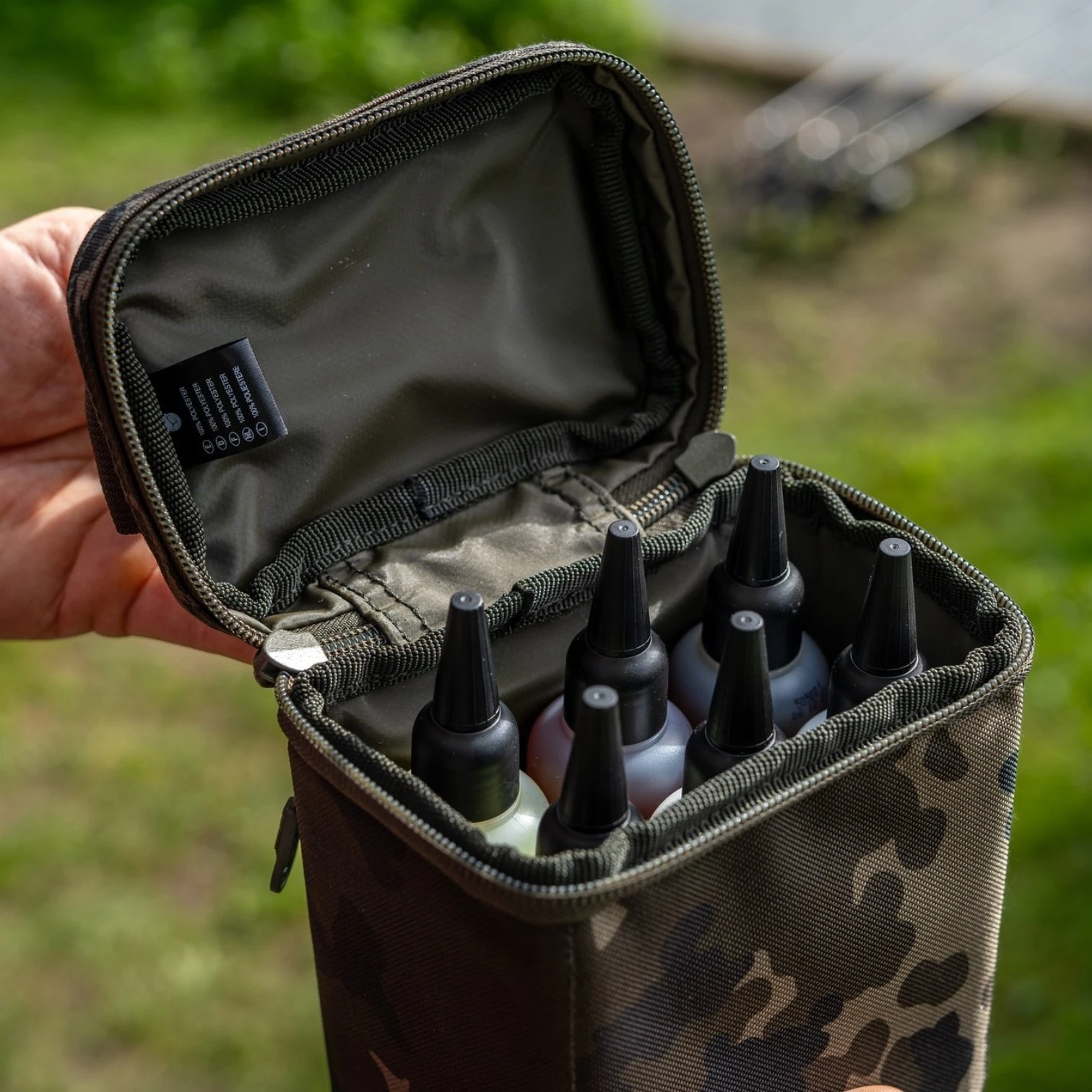 Korda Goo Bag Dark Kamo small size in use on the bank holding 6 Goo bottles