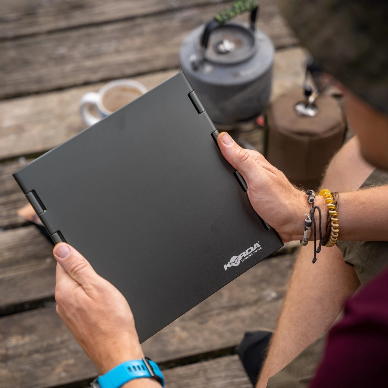 Angler holding Korda Windshield Large flat packed outdoors on the bank