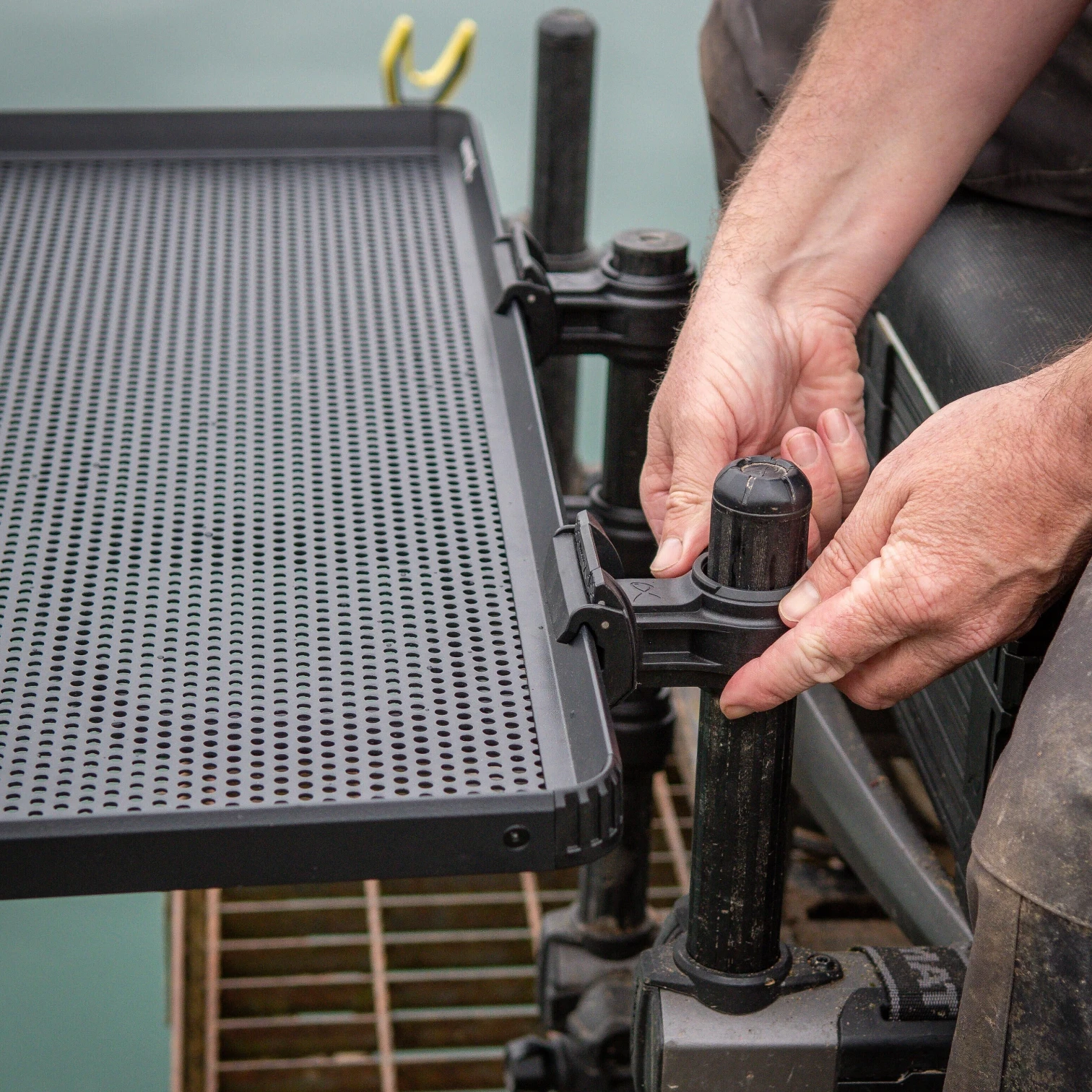 Close-up of the Matrix Sliding Side Tray leg brackets showing the adjustable mounting system and seatbox attachment points